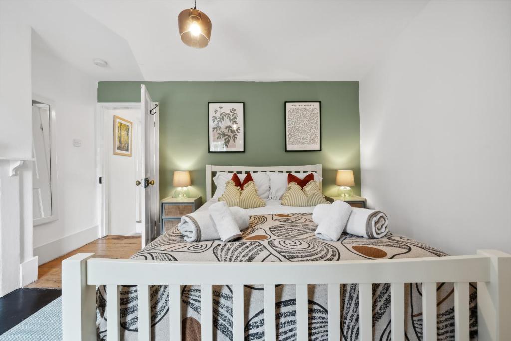 ein Schlafzimmer mit einem großen Bett mit grünen Wänden in der Unterkunft 2-Bedroom Stylish & Gorgeous, Cosy Westgate Cottage Retreat, Central Winchester, Free On-Street Parking Permit, with Garden, Close to Cathedral - Sleeps 6, Pets are Welcome - by Blue Puffin Stays in Winchester