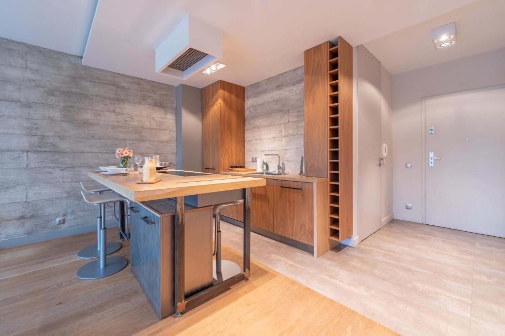 a kitchen with a wooden island in a room at Apartament Zeta Park 3 - w centrum Ustronia - Dream Apart in Ustroń