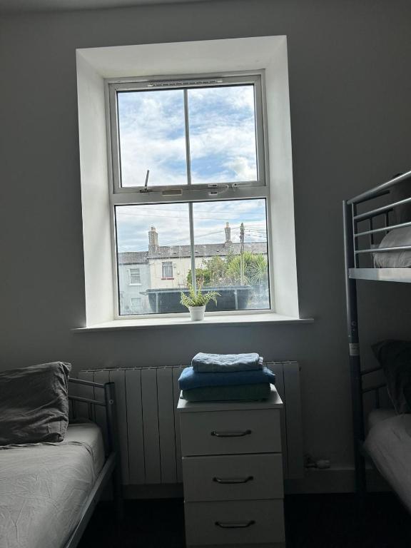 a window in a bedroom with a bed and a dresser at Sarsfields Communities in Dolphinʼs Barn