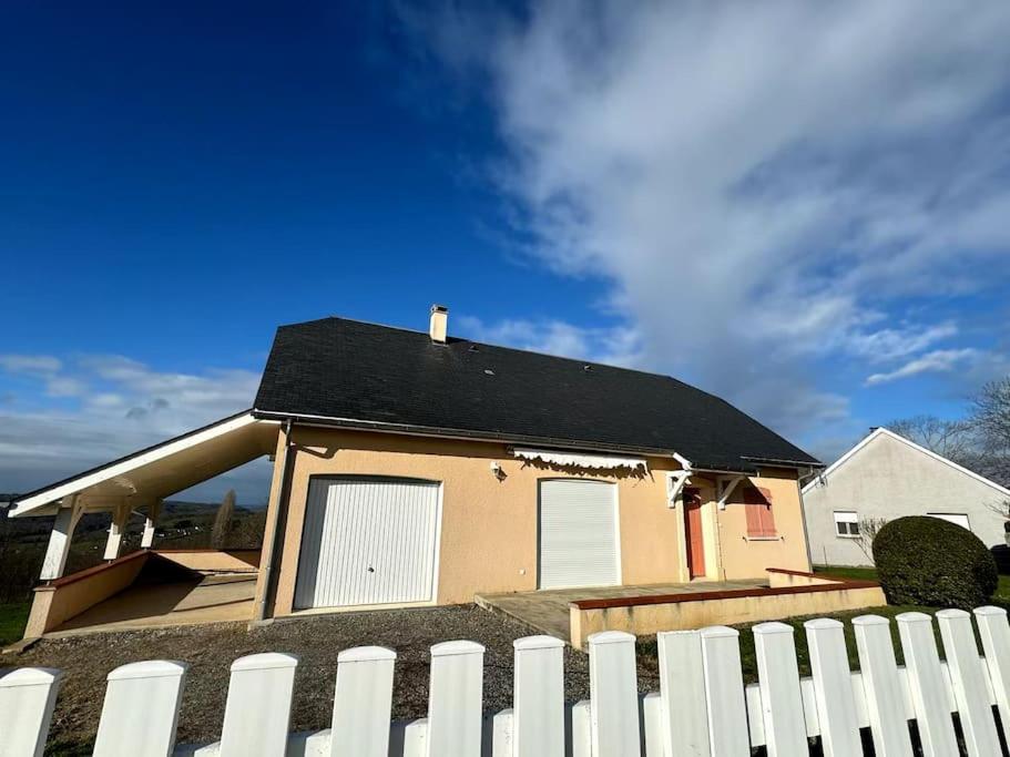 une maison avec une clôture blanche devant elle dans l'établissement Charmante Maison de Montagne, à Benqué