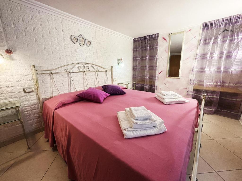 una camera da letto con letto, lenzuola e asciugamani viola di Apartment Aurora - Affitti Brevi Italia a Manfredonia