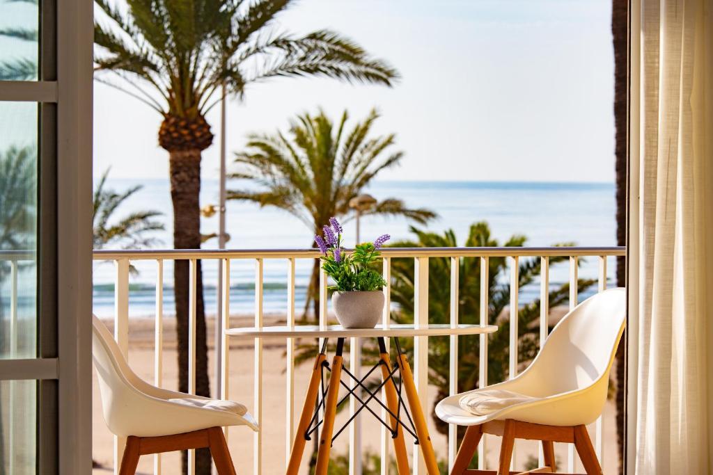 a balcony with a table and chairs and the beach at Cullera Horizon Apartment in Cullera