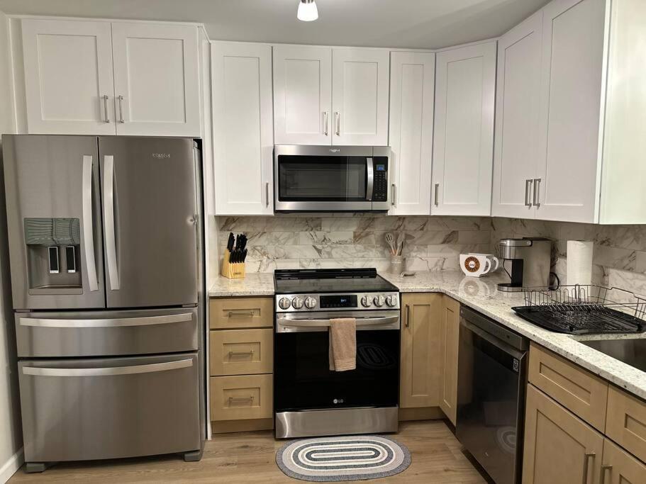 a kitchen with stainless steel appliances and white cabinets at Downtown Woodstock Home in Woodstock
