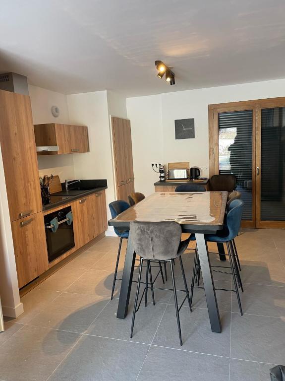 une cuisine avec une table et des chaises en bois dans l'établissement Bel appartement 3 pièces, 62 m2, 2 à 6 personnes, très calme, aux Gets