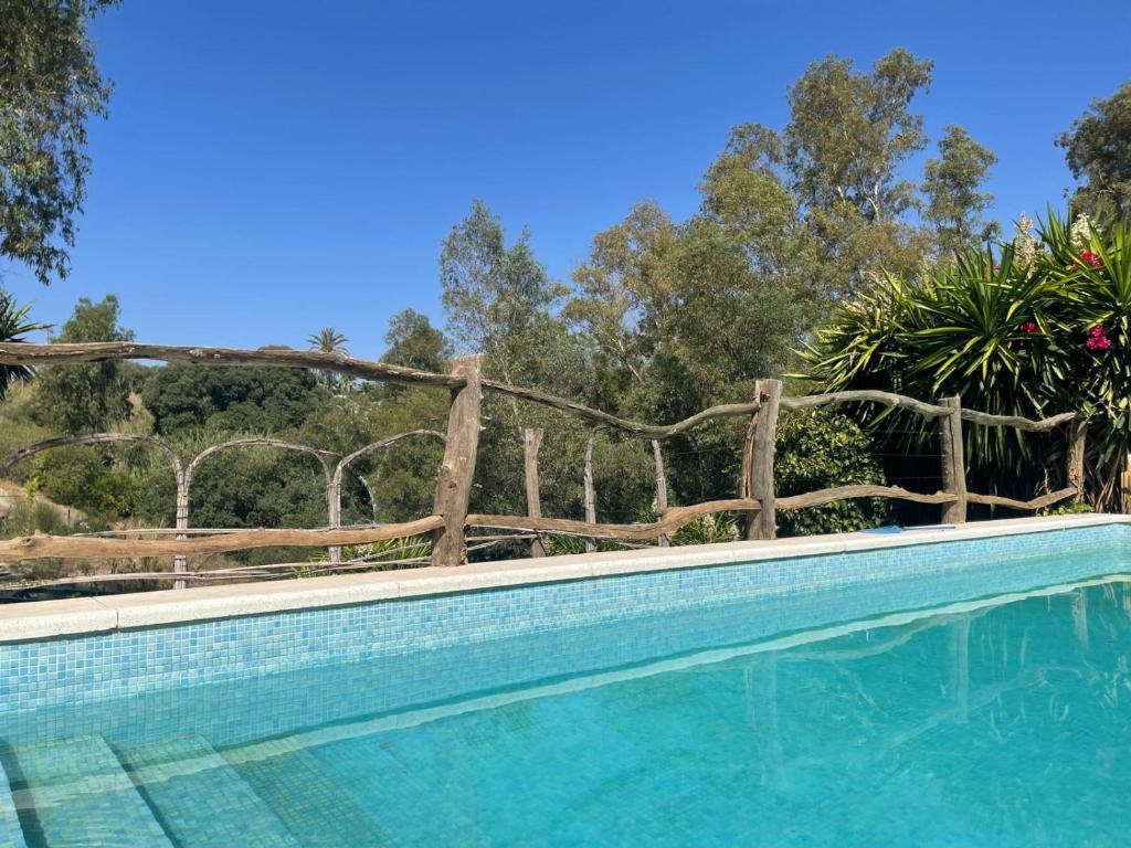 a swimming pool with a wooden fence around it at River Heart Lodges in Coín