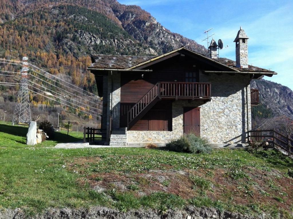 a small building with a balcony and a mountain at Chez les Rosset in La Salle