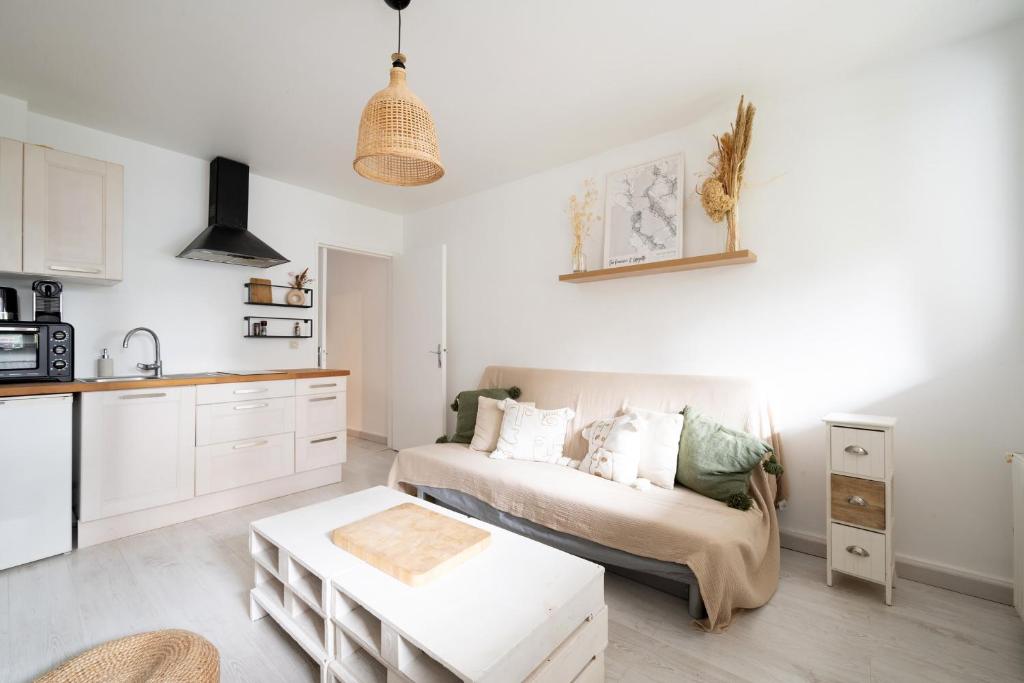 un salon avec un canapé et une cuisine dans l'établissement Appartement Lavoisier - Welkeys, à Puteaux