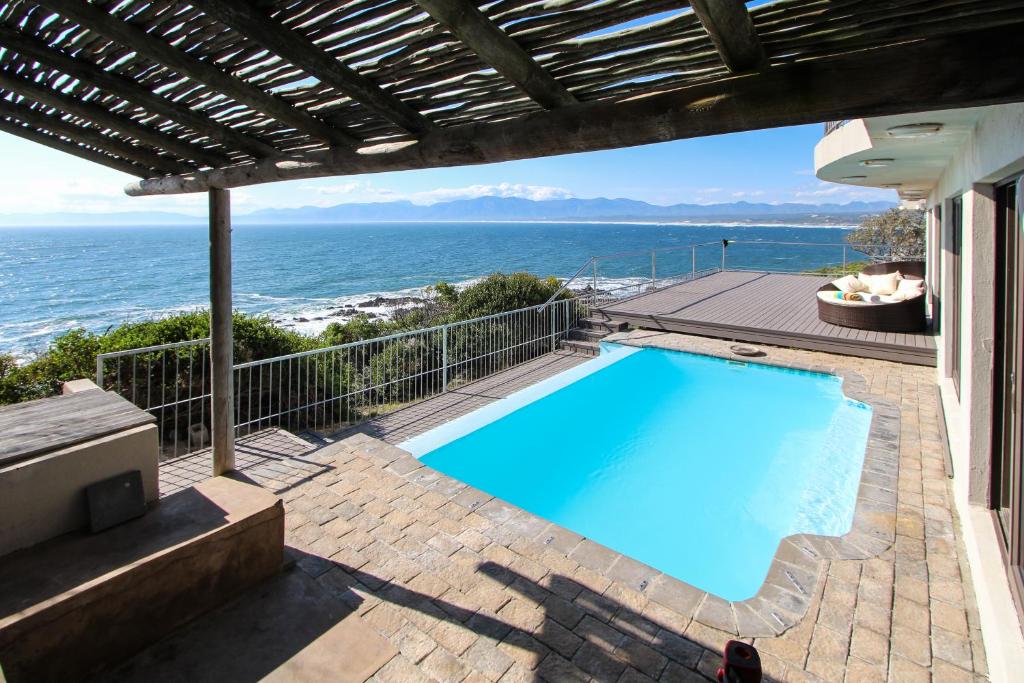 a swimming pool with a view of the ocean at Whale Huys Luxury Oceanfront Eco Villa in Gansbaai
