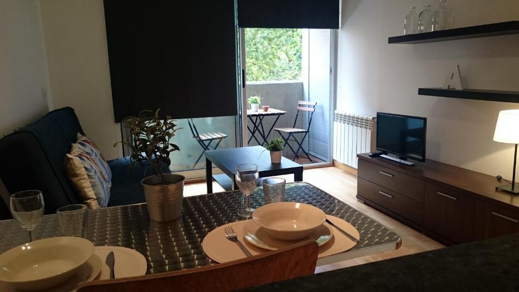 a living room with a table and a television at Apartment Bosch in Girona