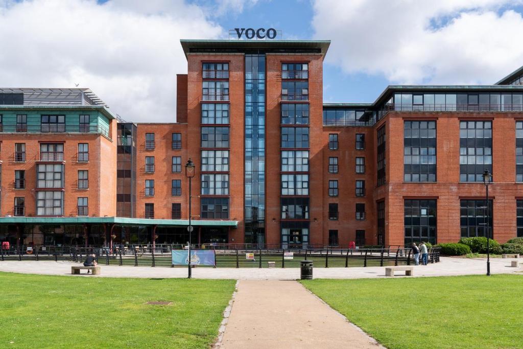 a large brick building with a sign on it at voco Belfast by IHG in Belfast