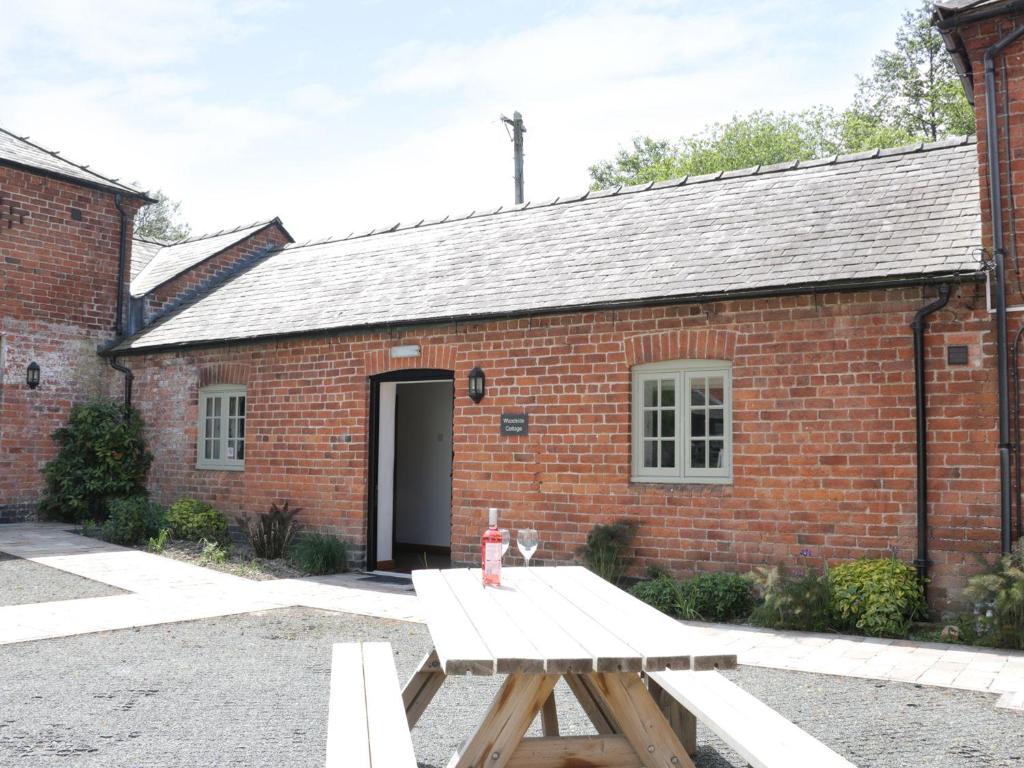 a picnic table in front of a brick building at Woodside Cottage in Newtown