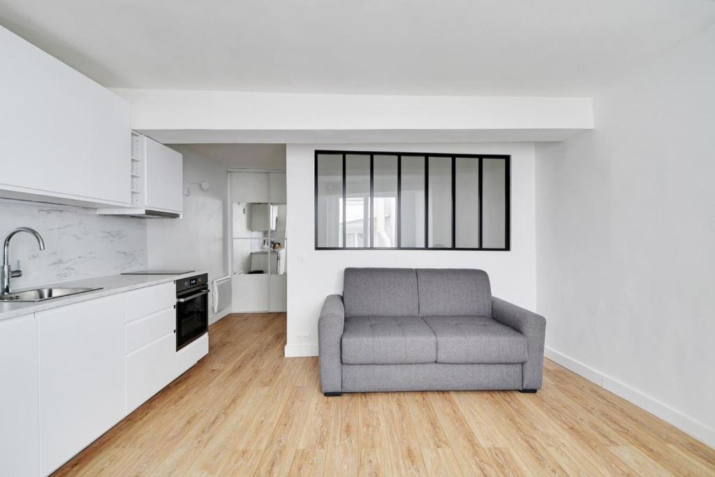 un salon avec un canapé dans une cuisine dans l'établissement Flexliving - Studio - Saint Antoine, à Paris