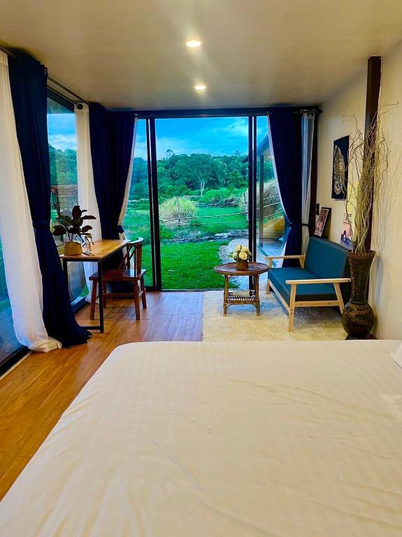 a bedroom with a bed and a room with a view at River-3Pok in Ban Mae Sapok Noi