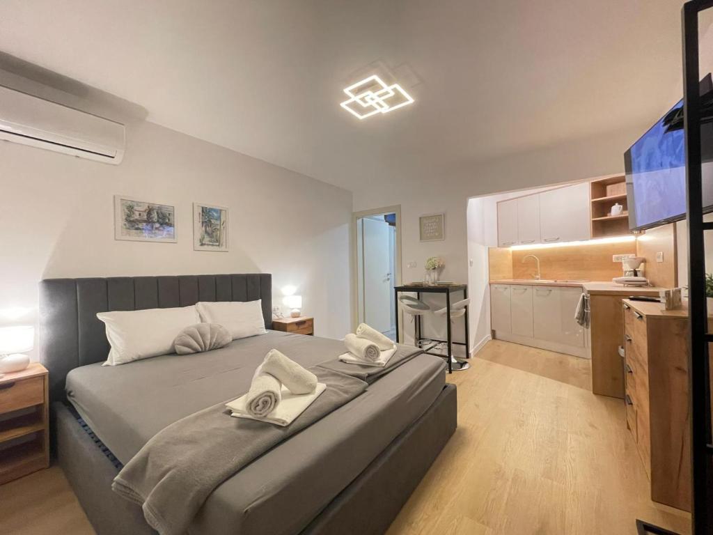 a bedroom with a large bed and a kitchen at Apartmani Jesenova in Selce