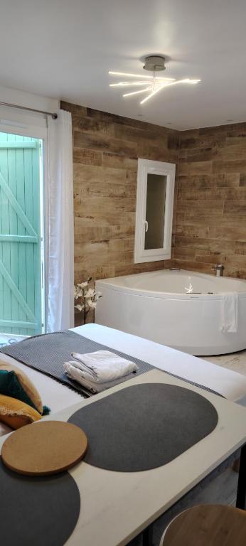 La salle de bains est pourvue d'une baignoire, d'un lit et d'un lavabo. dans l'établissement studio cosy balneo avec jardin, au Barcarès