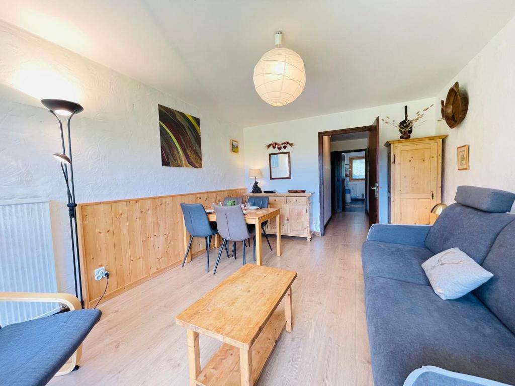 un salon avec un canapé bleu et une table dans l'établissement Appartement skis aux pieds avec jardin - 5 pers - Notre-Dame-de-Bellecombe - FR-1-505-9, à Notre-Dame-de-Bellecombe