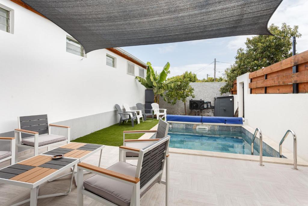 a patio with a table and chairs and a swimming pool at Kaz Sara in Saint-Pierre