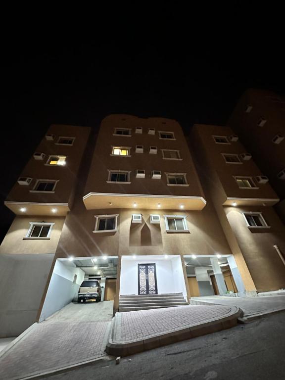 a large building at night with its lights on at نجوم السعد 9 in Al Masfalah