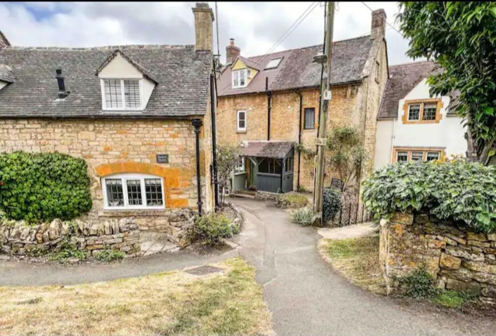 an old stone house with a pathway leading to it at Holland Cottage in Blockley