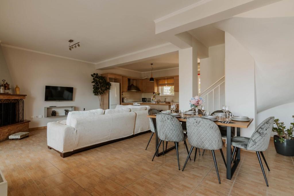 a living room with a white couch and a table and chairs at Elia House Nafplio in Nafplio