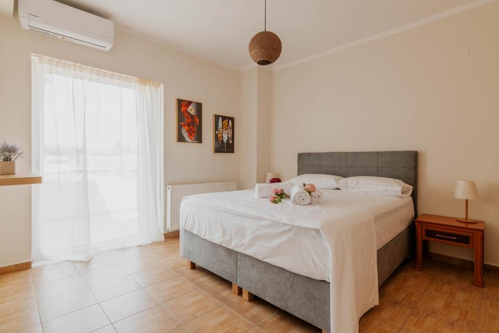 a bedroom with a large white bed with flowers on it at Elia House Nafplio in Nafplio