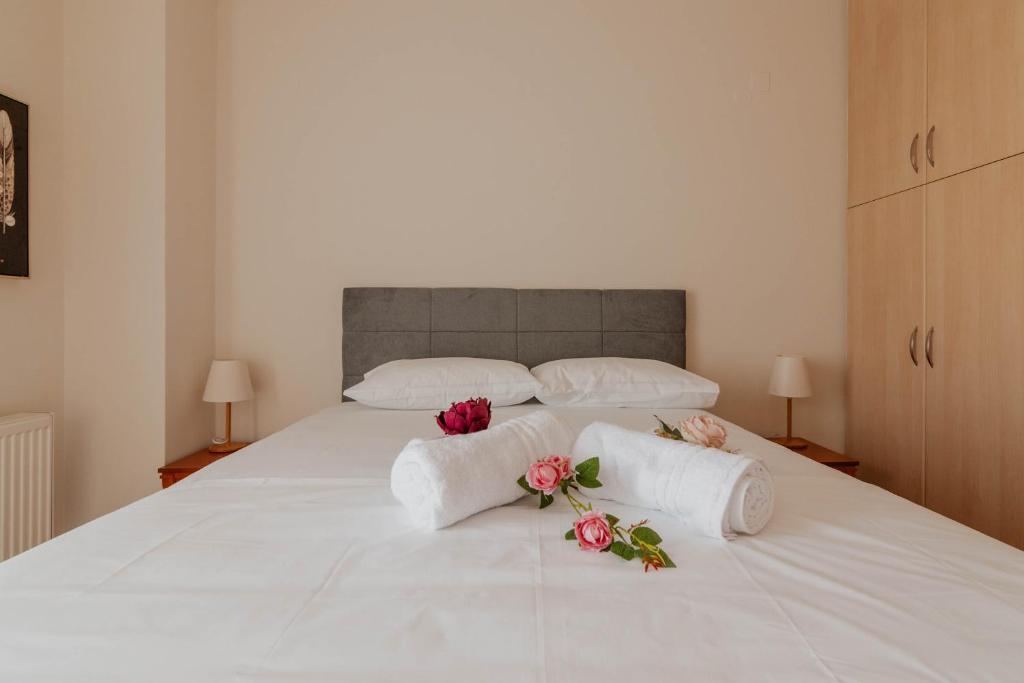 a white bed with two towels and flowers on it at Elia House Nafplio in Nafplio