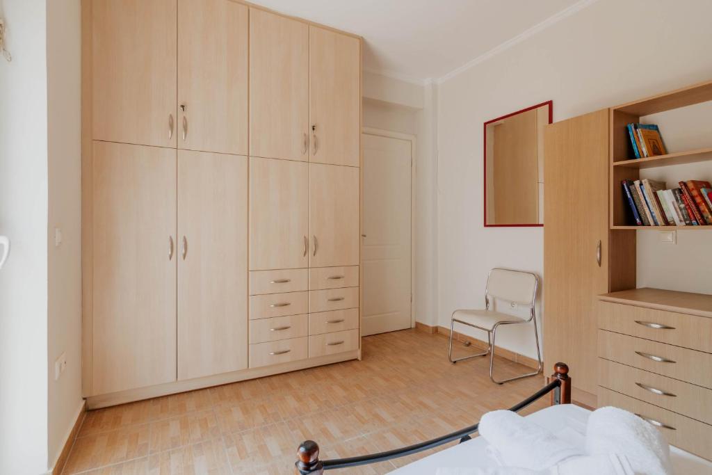 a bedroom with white cabinets and a chair in it at Elia House Nafplio in Nafplio