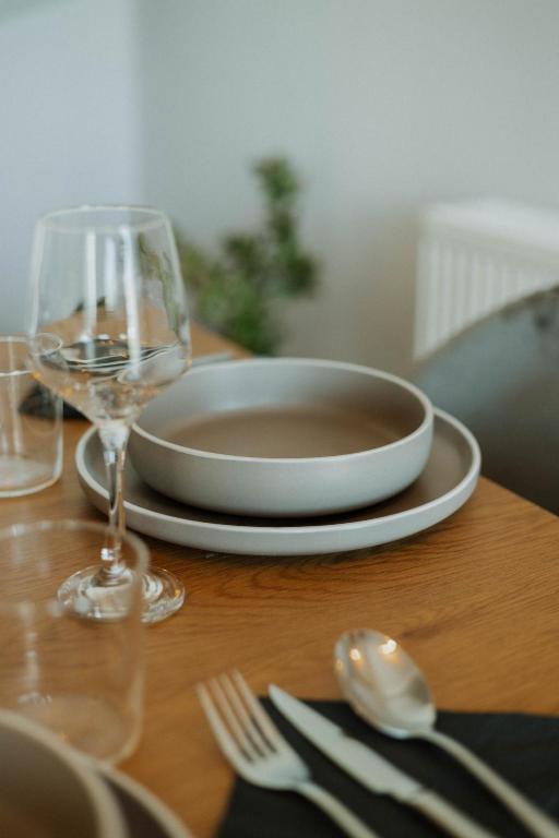 a wooden table with a plate and a glass of wine at Elia House Nafplio in Nafplio