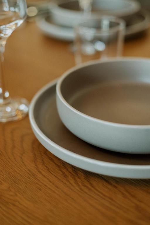 a table with plates and glasses on a wooden table at Elia House Nafplio in Nafplio