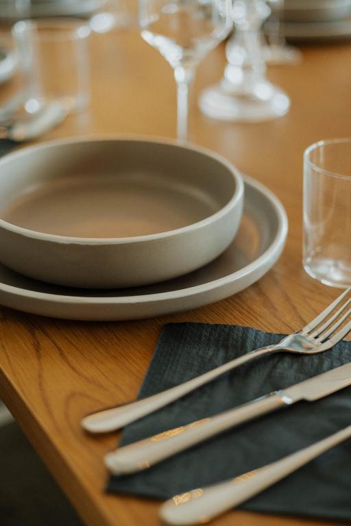 a wooden table with a plate and silverware on it at Elia House Nafplio in Nafplio