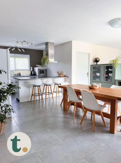 une cuisine et une salle à manger avec une table et des chaises dans l'établissement Tranquiloue - Maison moderne - Proche PuyduFou, à Mesnard-la-Barotière