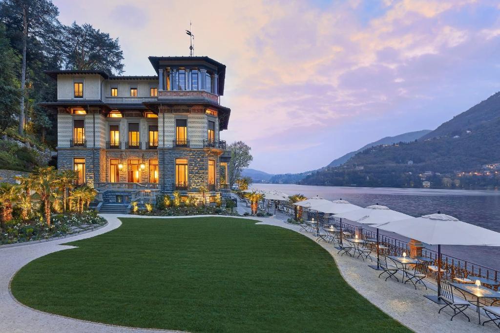una casa en el agua con un césped delante en Mandarin Oriental, Lago di Como, en Blevio