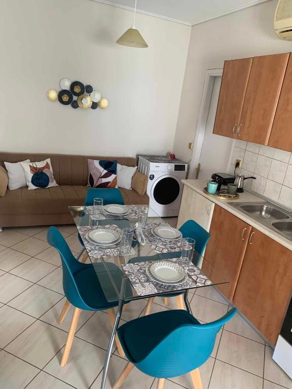 a kitchen with a table and blue chairs in a room at Aegean escape in Mytilini in Mytilene