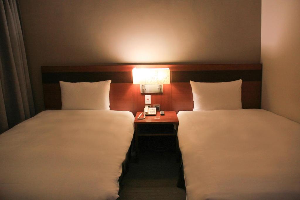 Postel nebo postele na pokoji v ubytování Guide Hotel Hsinchu Zhongyang