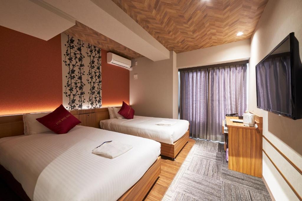 a hotel room with two beds and a flat screen tv at FIVE HOTEL OSAKA - Vacation STAY 72912v in Osaka