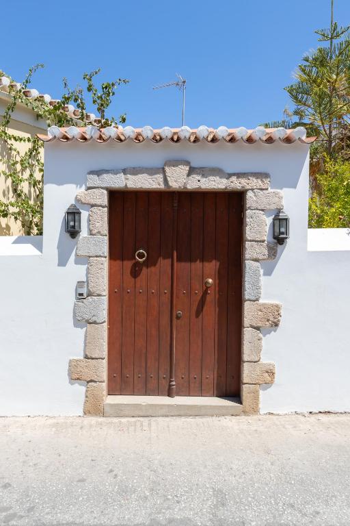 a wooden door in a stone wall at Votsalo Spetses in Spetses