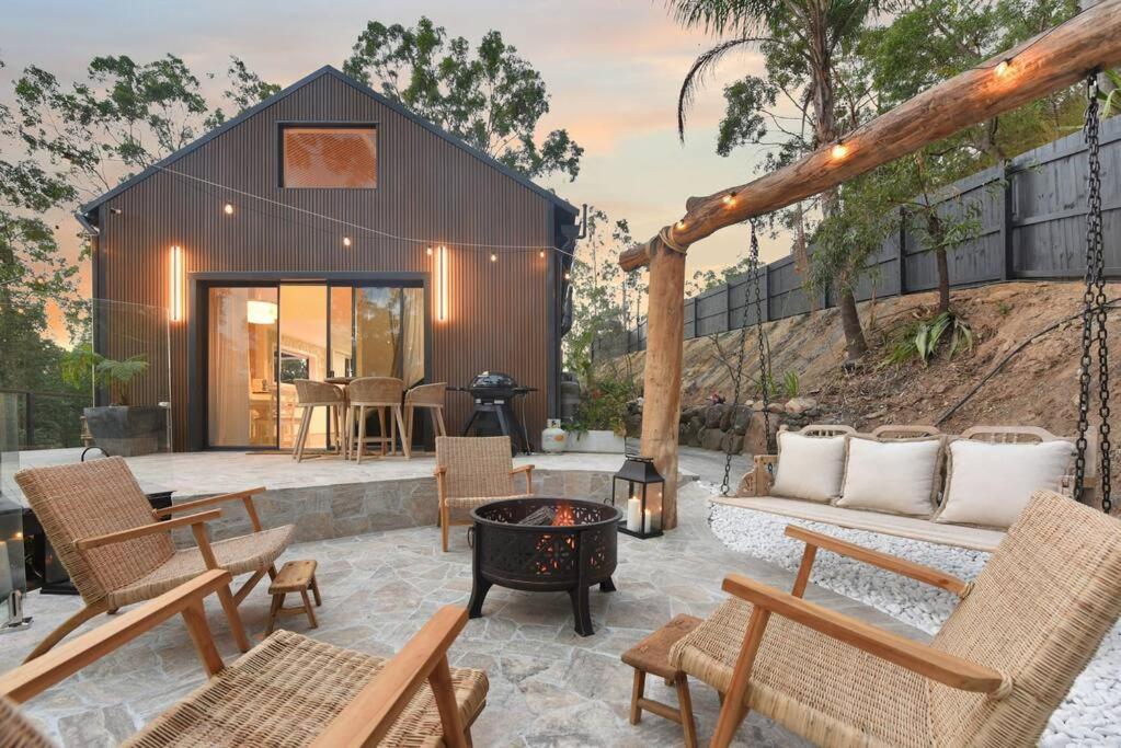 a backyard patio with chairs and a fire pit at Brand New Gold Coast Luxury Retreat in Mudgeeraba