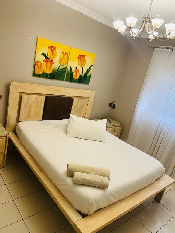 a bedroom with a bed with a wooden frame at Villa Kristine 3 in Windhoek