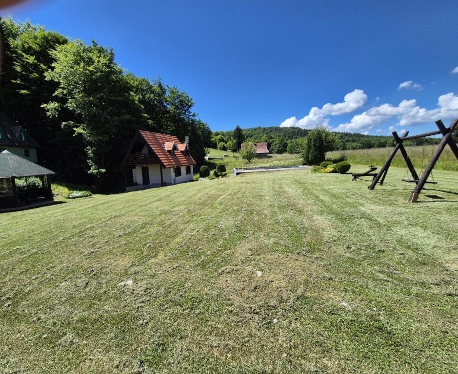 a large yard with a fence and a house at Kuća za odmor Mališevac in Gornja Koprivna