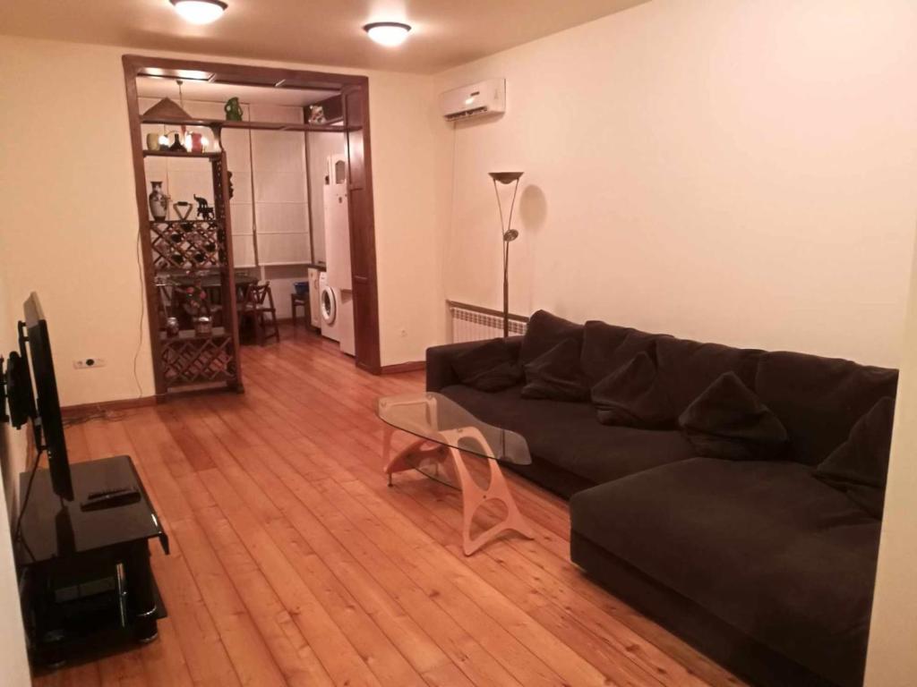 Una sala de estar con un sofá y una mesa de cristal. en Отличный отдых в центре Батуми, en Batumi