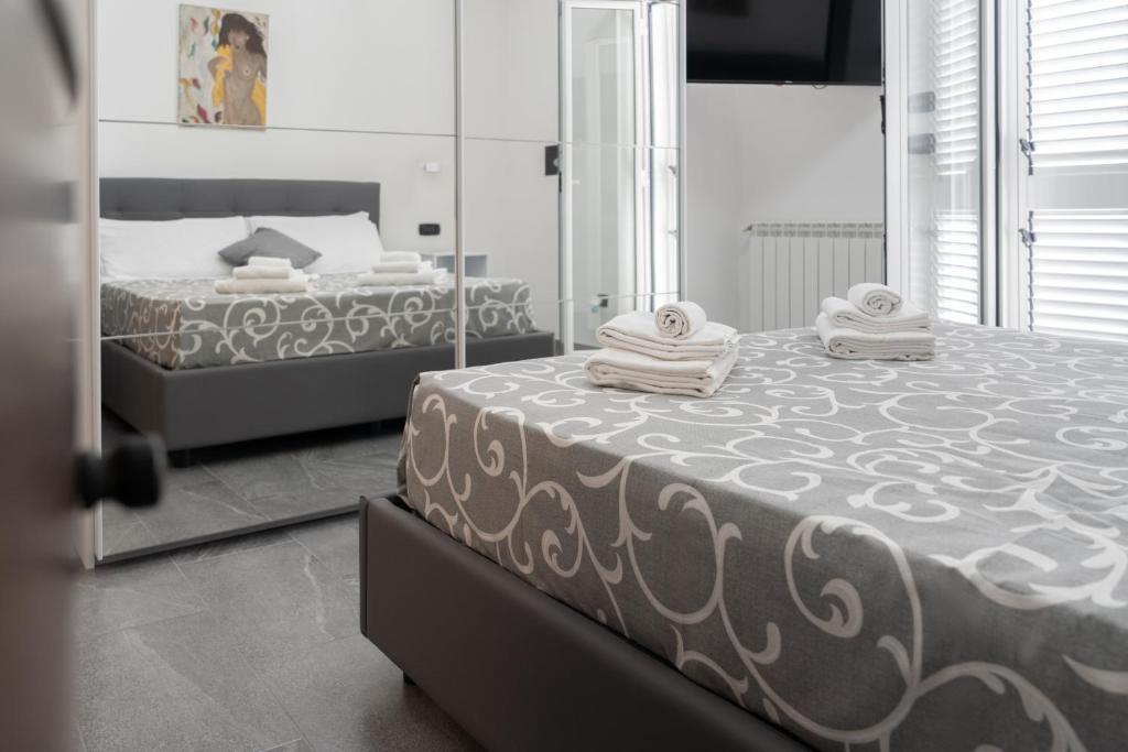 a bedroom with two beds with towels and a mirror at Light stadium in Taormina