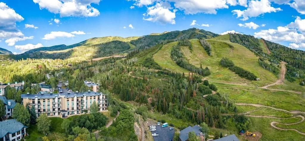 a building on a hill next to a mountain at Storm Meadows Club A-219, Corner Unit, Amazing Panoramic Views, Ski In Ski Out, Club Amenities in Steamboat Springs