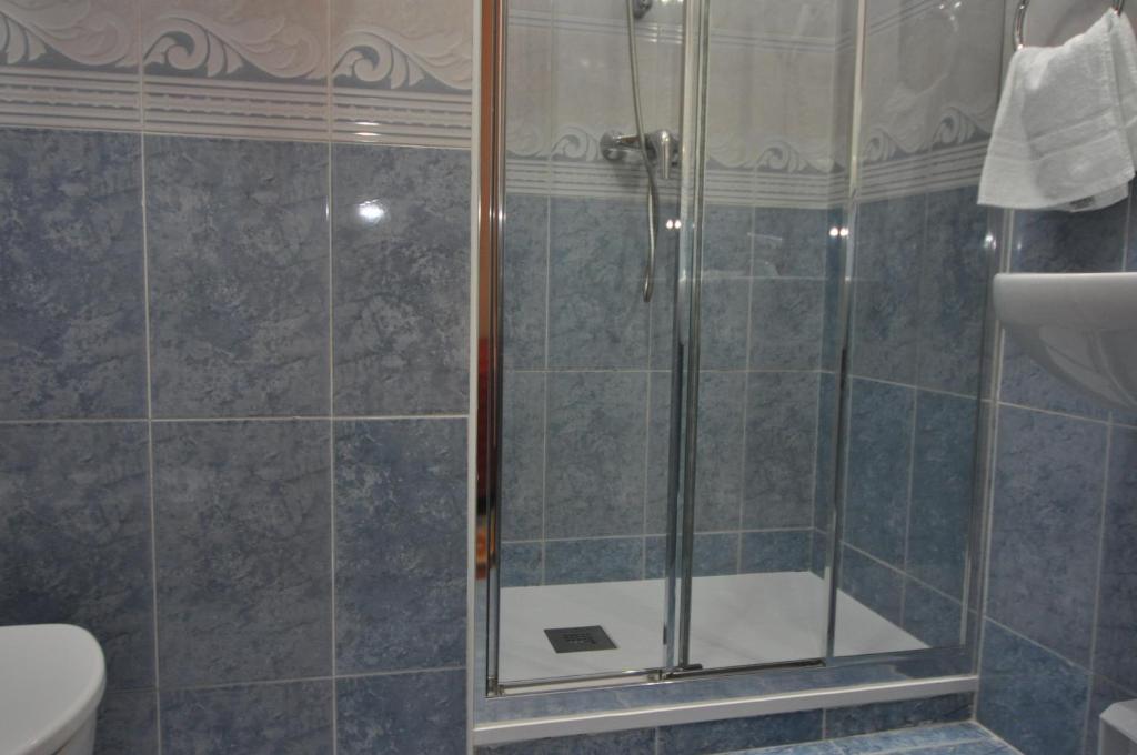 a shower with a glass door in a bathroom at Pension Alameda in San Sebastián