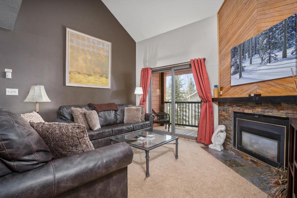 sala de estar con sofá de cuero y chimenea en 3 Hot Tubs, Private Shuttle in Winter, Gas Fireplace, Free Bus, en Steamboat Springs
