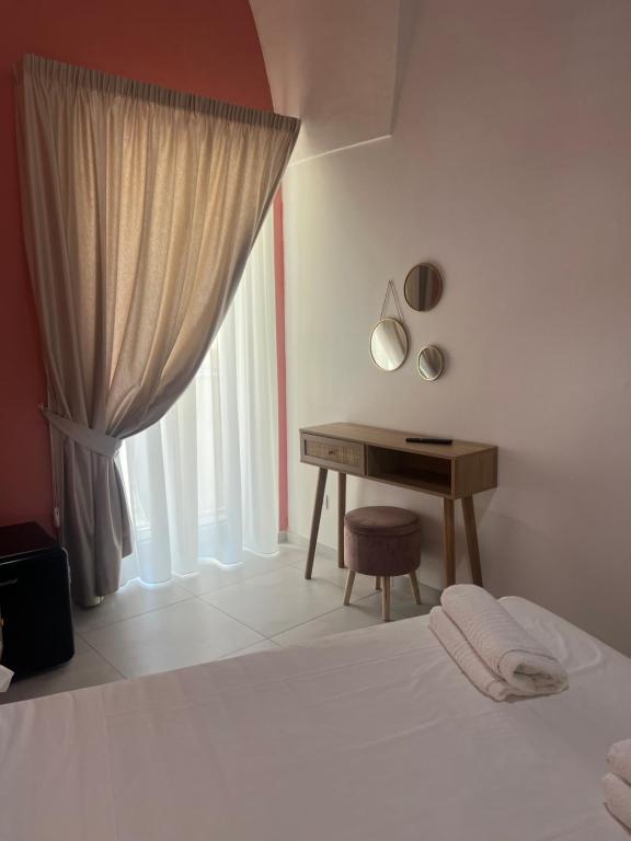 a bedroom with a bed with a desk and a window at Casa mia MadamA in Gaeta
