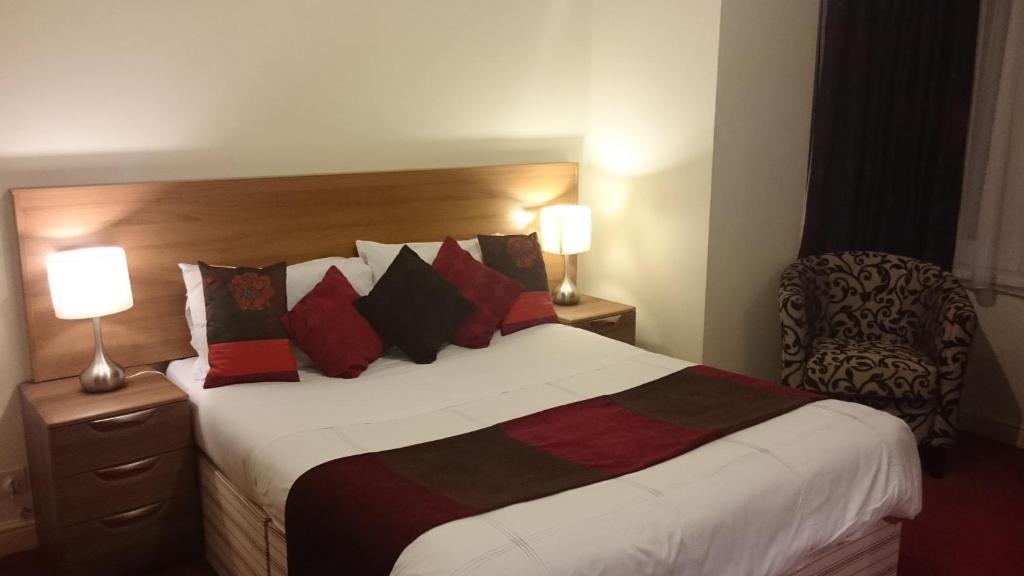 a bedroom with a large bed with red and black pillows at Gateway Express in Newport