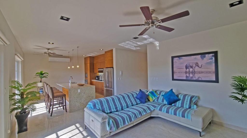 a living room with a couch and a ceiling fan at Palacio Huatulco - 5C in Santa Maria Huatulco