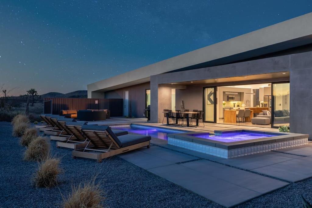 una casa con piscina e sedie a sdraio di W House Luxe Near Park Heated Pool & Spa a Joshua Tree