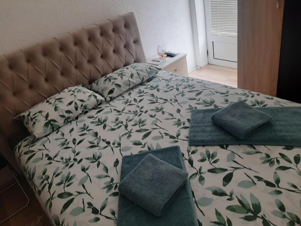 a bedroom with a bed with green leaves on it at Studio D&I in Vranje