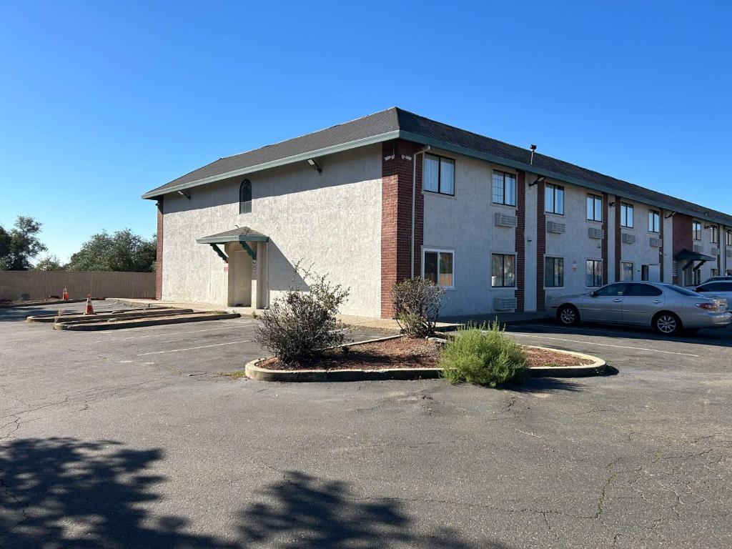 a building with a car parked in a parking lot at Studio 6 Suites Cameron Park, CA Folsom in Cameron Park